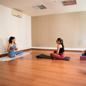 Aula de yoga em estúdio com espelhos.