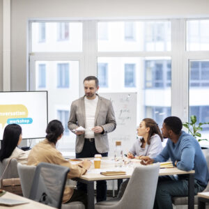 Grupo de adultos assistindo a uma aula no escritório