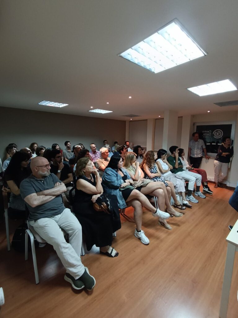 Sala de aula, com pessoas sentadas a assistir um filme