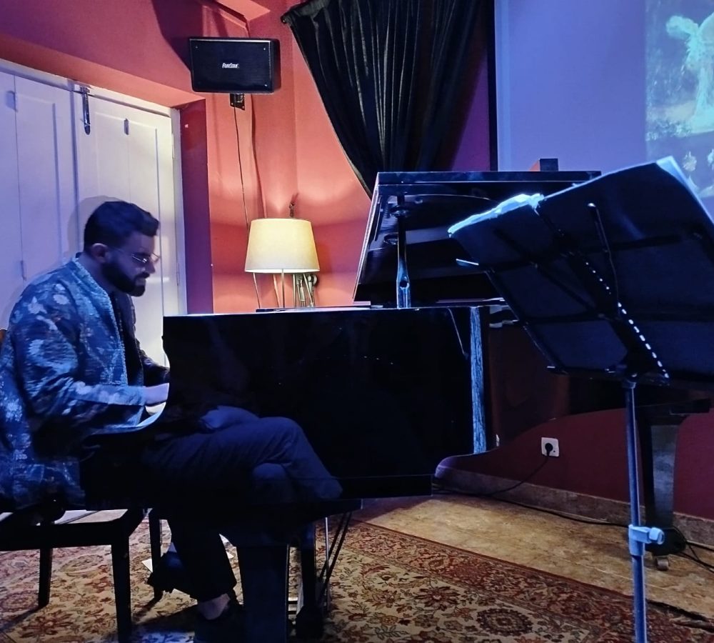 Homem tocando piano em estúdio musical.
