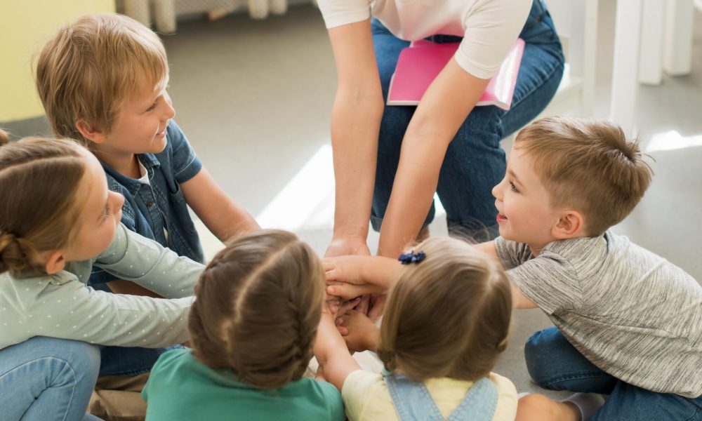 Professora brinca com alunos de 3 e 4 anos.